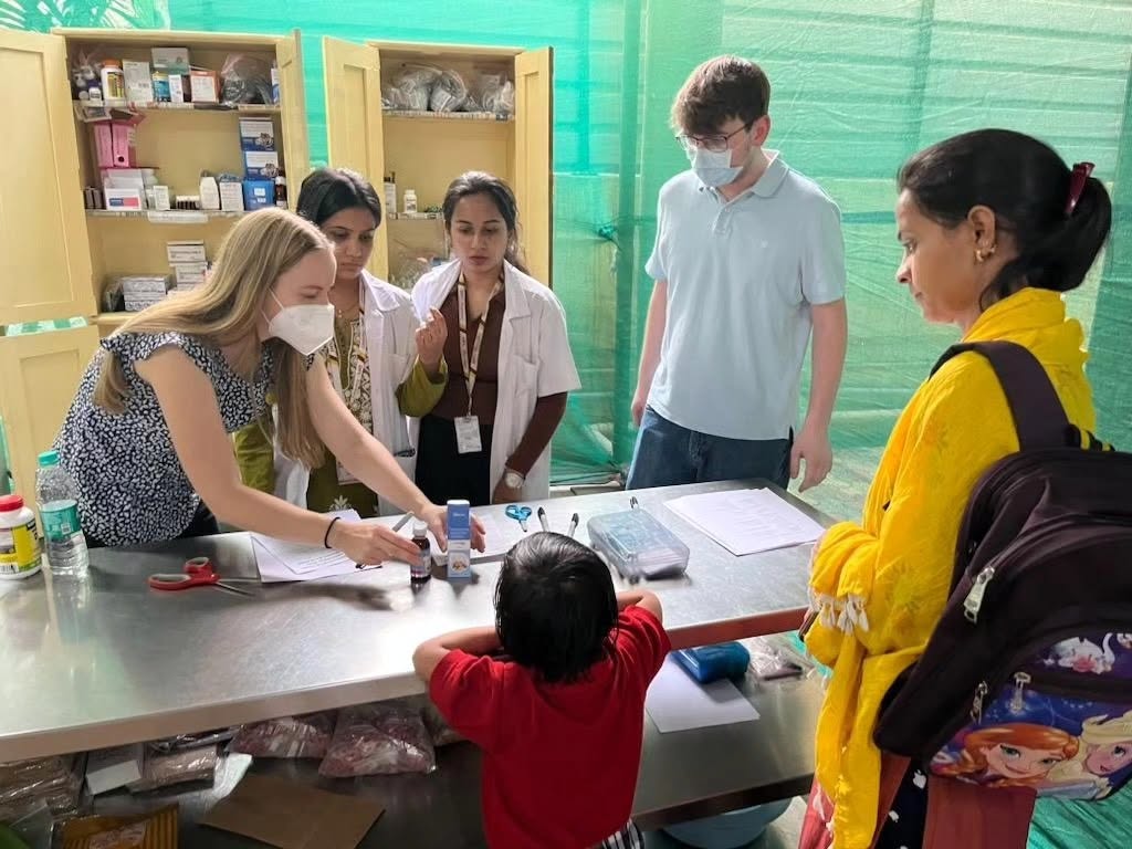 A group of doctors speak to a young boy with his mother present